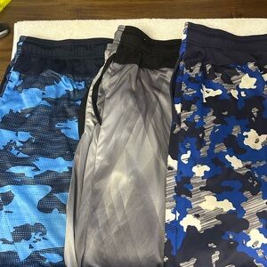 3 pairs of shorts 2 Blue Camouflage and 1 gray with red trim.